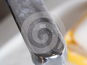 Water tap close-up in the bathroom with a white coating.