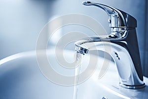 Water tap , faucet. Flow water in bathroom with sink. Modern clean hause. Backround hygiene.