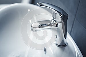 Water tap , faucet. Flow water in bathroom with sink. Modern clean hause. Backround hygiene