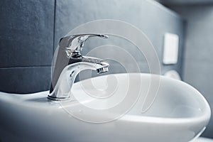 Water tap , faucet. Flow water in bathroom with sink. Modern clean hause. Backround hygiene.