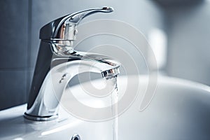 Water tap , faucet. Flow water in bathroom with sink. Modern clean hause. Backround hygiene.