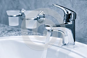 Water tap, faucet. Flow water in bathroom with sink. Modern clean hause. Hygiene concept