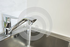 Water tap, flow water in bathroom with sink. Modern clean hause. Hygiene concept