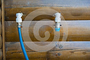 Water taps for garden hoses connection. Wooden outer wall of woodshed