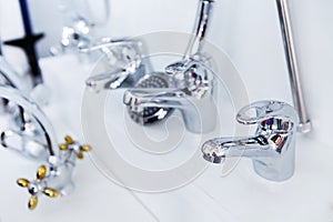 Water taps on a white ceramic sink. Plumbing trade in the store