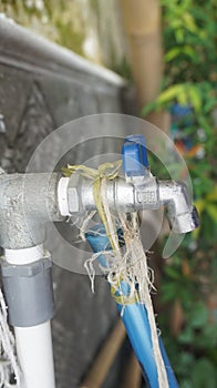 Water taps and white pipes to drain water from the well to the bathtub. Photo of bath accessories