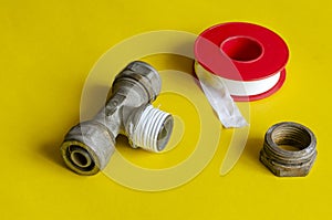 Water tee splitter, nut and sealing tape on a yellow background