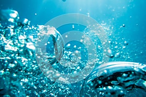 Water texture. Bubbles in underwater. Sun light in blue ocean.