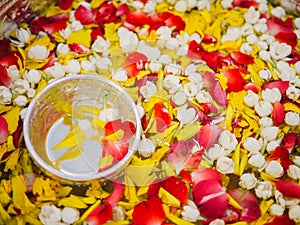 Water with thai perfume in water dipper with colorful flowers petal and garland for Songkran festival, Thailand, Bowl with flowers