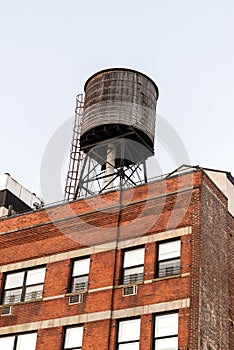 Water tower atop a red brick building photo