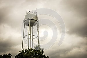 A water tower with cloudy skies as the background