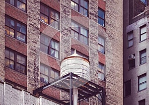 Water tower on a roof of an old building in Manhattan, color toning applied, New York City, USA