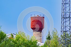 Water tower in a village against the blue sky