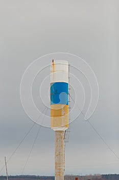 Water tower with white, blue and orange stripes