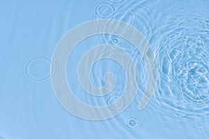 Water tranquil ripple background. Water texture, circles and bubbles on a liquid blue surface. Cosmetic products and