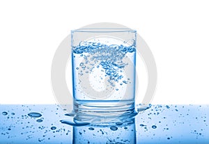 Water in transparent glass with drops and bubbles isolated over