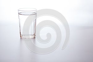 Water in transparent glass on gray background. purified fresh drink water