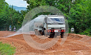 water truck sprays water on new road construction project. photo