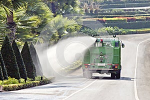 Water truck watering bush in park