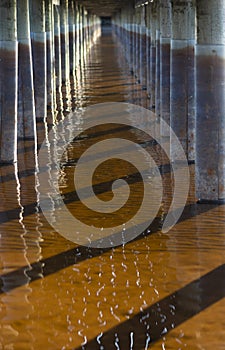 Water under bridge with refelection of sunlight