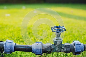 Water valve pipe in the green garden grass field