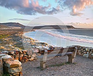 Water, view and beach sunset with peace, beauty and location tranquility in nature. Sea bench, freedom and ocean sunrise
