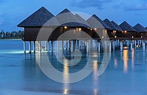 Water villas on Maldives resort island at night