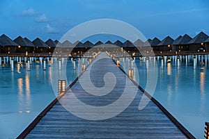 Water villas on Maldives resort island at night