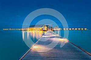 Water villas on Maldives resort island in sunset