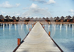 Water villas in Maldives in a sunny day, island paradise relax