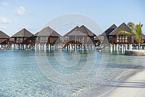 Water villas in Maldives in a sunny day, island paradise relax