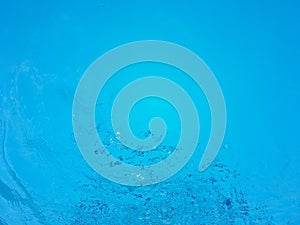 Water wave with ripple inside blue swimming pool surface background
