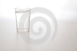 Water wave in transparent glass and puddle on gray background. purified fresh drink water