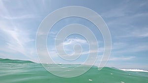 water wave underwater blue ocean pool wide panoramic background sandy bottom isolated from blue sky and clouds. Slow