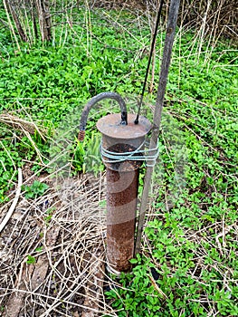 water well pipe with submersible pump in backyard