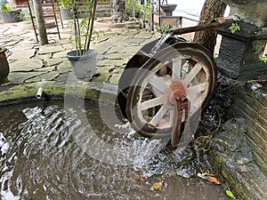 Water wheel in a pond in a park for decoration.