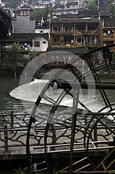 A water wheel powered by the Tuo Jiang River illustrates Old World charm in Fenghuang Ancient City in Tibet, China