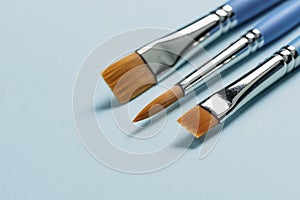 Watercolor paint brushes on light blue background