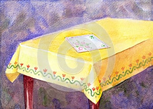 Watercolor painting table with yellow cloth and an embroidered n