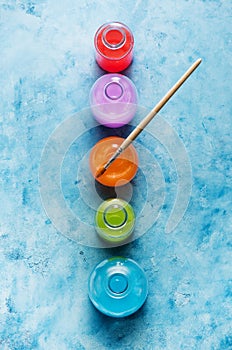 Watercolor paints in glass bottles and the artist`s palette.