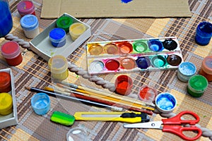 Watercolor paints and paper closeup for drawing, artistic creation at home, workspace for make creative artwork
