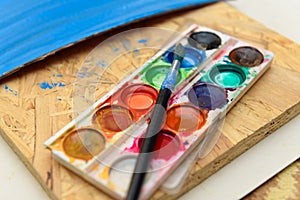 Watercolor paints and paper closeup for drawing, artistic creation at home, workspace for make creative artwork