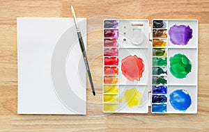 Watercolor paints set in white palette with white paper for background