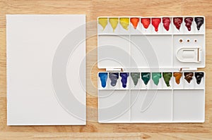 Watercolor paints set in white palette with white paper for background