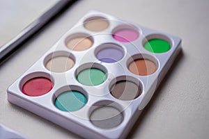 Watercolor palette on a white table in close up concept