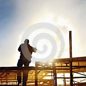 Watercolor of roofer working on roof structure at construction site