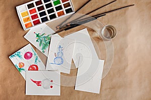 Watercolour seasonal greetings postcards on a table with palette and brushes