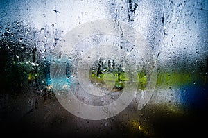 Waterdrops on a glass surface windows with closeup cityscape background