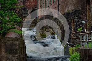 Waterfall through ancient industry buildings