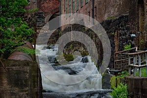 Waterfall through ancient industry buildings photo